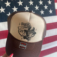 Load image into Gallery viewer, Brown & Cream Trucker hat with Graphic that Says Smoking Joe 24 and Picture of Trump with Cigar and American flag background
