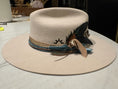 Load image into Gallery viewer, Close up detailed picture of a styled flat brim hat with a sunshine brand, silks,velvet blues and golds with feathers. The perfect cream colored hat.